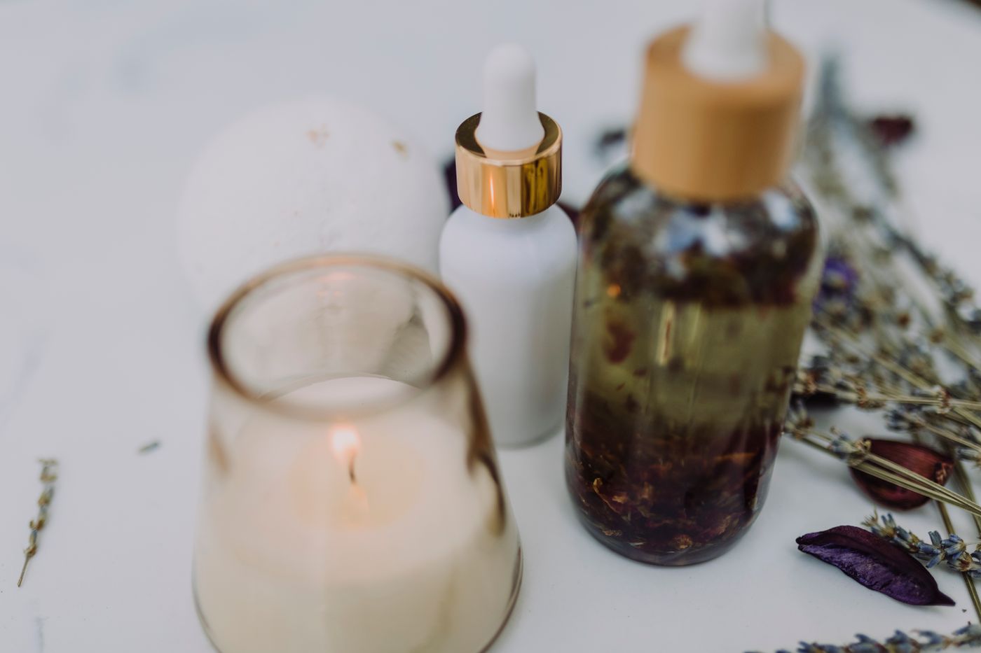 Candle and essential oil bottles with dried lavender